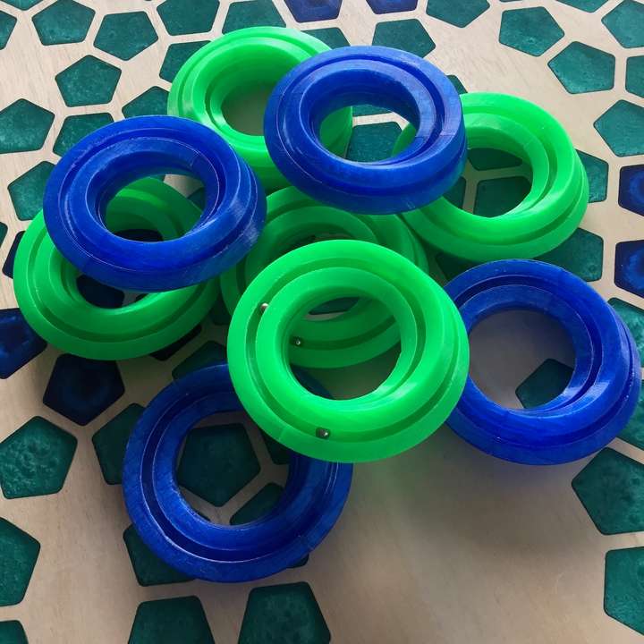 Green and blue donut shaped toys I call a Mobiüs Rollers